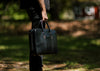 Model holding vegetable tanned black leather Counselor Briefcase by handles